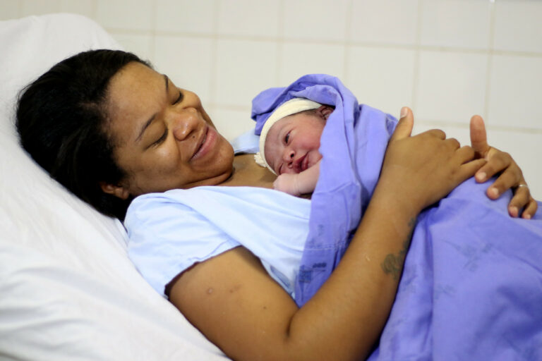 Mulher segurando bebê após o parto